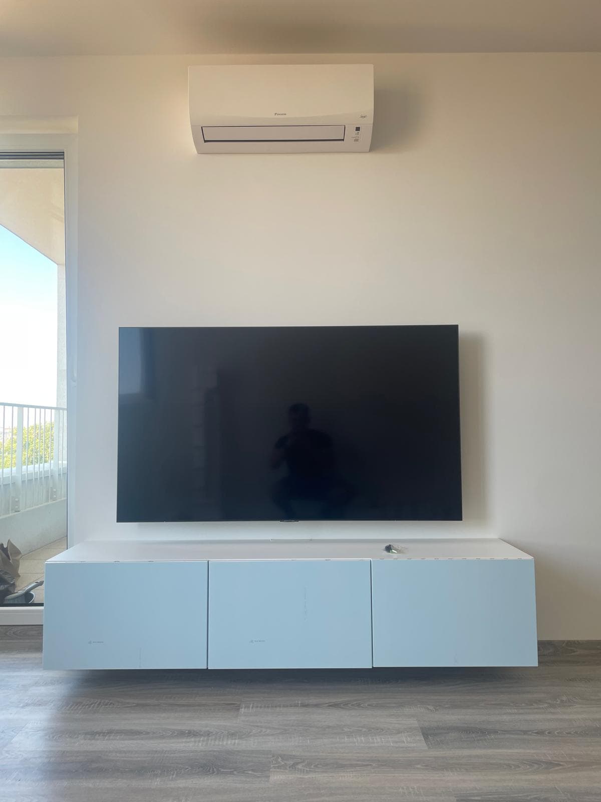 TV nad bielou závesnou zostavou, skryté káble